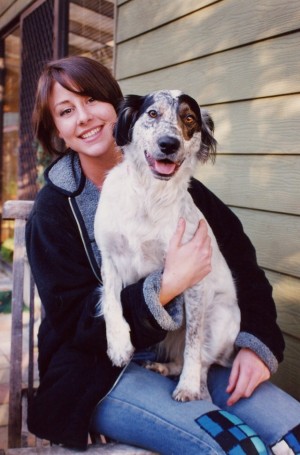 Image of a young adult women sitting on the porch with her dog